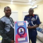 The Registrar of IRAMN presenting a congratulatory card to a member Dr Audi - the Commander- General of NSCDC in his office